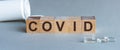 COVID word written on wood block. Covid text on grey table for your desing