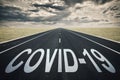 Covid-19 written on a road, dark clouds, coronavirus epidemic concept