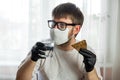 COVID-19. Young caucasian man in glasses, white mask and black gloves with a slice of bread and a cup of water in his hands. Royalty Free Stock Photo