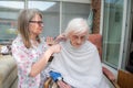 Elderly woman has hair cut by her carer during Corona virus lockdown at home Royalty Free Stock Photo