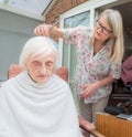 Elderly woman has hair cut by her carer during Corona virus lockdown at home Royalty Free Stock Photo