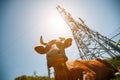 A cow is lying on a green meadow in an apple orchard against the background of a power line of a substation, a sunny day Royalty Free Stock Photo