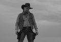 Cowboy in black suit and cowboy hat. Man with west vintage pistol revolver gun and marshal ammunition. American western Royalty Free Stock Photo