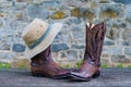 Cowboy boots hat against stone wall background Royalty Free Stock Photo