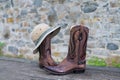 Cowboy boots hat against stone wall background Royalty Free Stock Photo