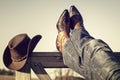 Cowboy boots and hat with feet up resting with legs crossed Royalty Free Stock Photo