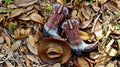 Cowboy boots and hat laying flat in a bed of leaves Royalty Free Stock Photo