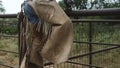 Cowboy chaps with fringe on leather, climbing fence.