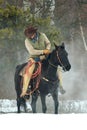 Cowboy checking is stirrups Royalty Free Stock Photo