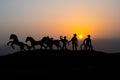 Cowboy concept. Silhouette of Cowboys at sunset time. A cowboy silhouette on a mountain with an yellow sky.