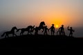 Cowboy concept. Silhouette of Cowboys at sunset time. A cowboy silhouette on a mountain with an yellow sky.