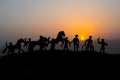 Cowboy concept. Silhouette of Cowboys at sunset time. A cowboy silhouette on a mountain with an yellow sky.