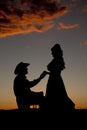 Cowboy couple silhouette him kneel Royalty Free Stock Photo