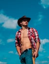 Cowboy couture. Portrait of young man wearing cowboy hat and looking up while standing against sky background. Fashion Royalty Free Stock Photo