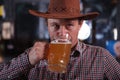 Cowboy drinking beer at the saloon