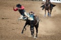 Cowboy falling off a bucking bronco