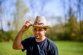 Cowboy in Field Tipping Hat Grinning Royalty Free Stock Photo