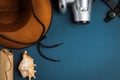 Cowboy hat, camera, compass, old paper scroll and seashell on a blue background Royalty Free Stock Photo