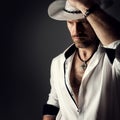 Cowboy in Hat. Handsome Bearded Man Fashion Portrait over Black Background. Sexy Brutal Men Model Unshaved in White open Collar Royalty Free Stock Photo