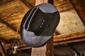 Cowboy hat hanging on a pole in a stable