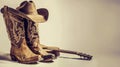 a cowboy hat, lasso, and boots set against a white background, accompanied by a guitar, evoking the spirit of the Wild Royalty Free Stock Photo