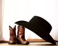 Cowboy hat leaning on small boots Royalty Free Stock Photo