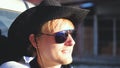 Handsome smiles cowboy in hat and sunglasses traveling in a pickup truck in sunny day Royalty Free Stock Photo