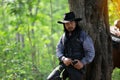 Cowboy on his horse walking through dust in the forest Royalty Free Stock Photo