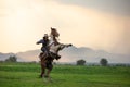 Man riding horse in field against sunset and mountain Royalty Free Stock Photo