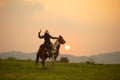 Man riding horse in field against sunset and mountain Royalty Free Stock Photo