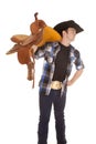 Cowboy holding saddle on shoulder look side Royalty Free Stock Photo