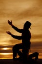 Cowboy kneel silhouette both hands up Royalty Free Stock Photo