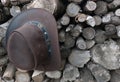 Cowboy leather brown hat hanging on an old woodpile outdoors in natural light Royalty Free Stock Photo