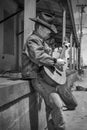 Cowboy playing acoustic guitar wearing jeans outdoors Royalty Free Stock Photo