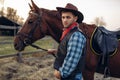 Cowboy poses with horse on texas ranch, wild west