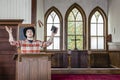 Cowboy preacher wearing a cowboy hat preaching to his people