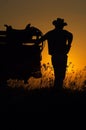 Cowboy resting on truck at sunset