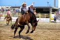 A cowboy rides a bucking bronco at the Warbonnet Roundup Rodeo Royalty Free Stock Photo