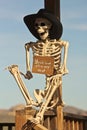 A Cowboy Skeleton Sits Against a Post