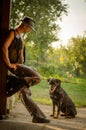 Cowboy stands with dog at the barn. A handsome man with a hat. A sympathetic man.