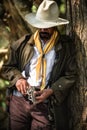 a cowboy stands to hold a gun