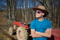 Cowboy teenager standing near the tractor Royalty Free Stock Photo