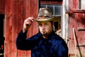 Cowboy Tipping Hat in front of Barn