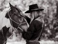 Cowboy touches the horse with love Royalty Free Stock Photo