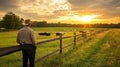 Cowboy watching sunset over pasture Royalty Free Stock Photo