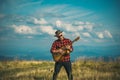 Cowboy western men. Young guy plays guitar at sky. Royalty Free Stock Photo