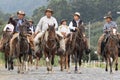 Cowboys on horse back on a country road