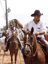 Cowboys mounted on Quarter Horses prepare for the lasso test on a dirt trac