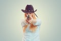 Cowgirl aiming at camera with gun