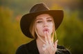 Cowgirl in cowboy hat with finger gun. Beautiful woman in fashion hat. Sensual portrait of elegant young woman outdoors Royalty Free Stock Photo